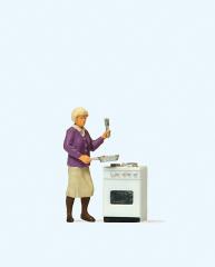 Femme devant sa cuisiniere